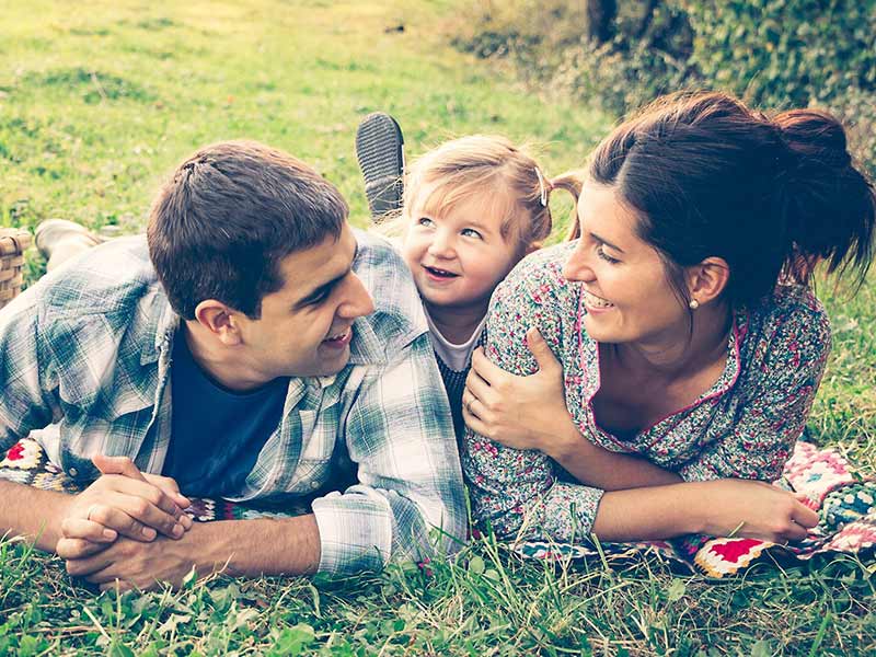 A family laying on the glass field