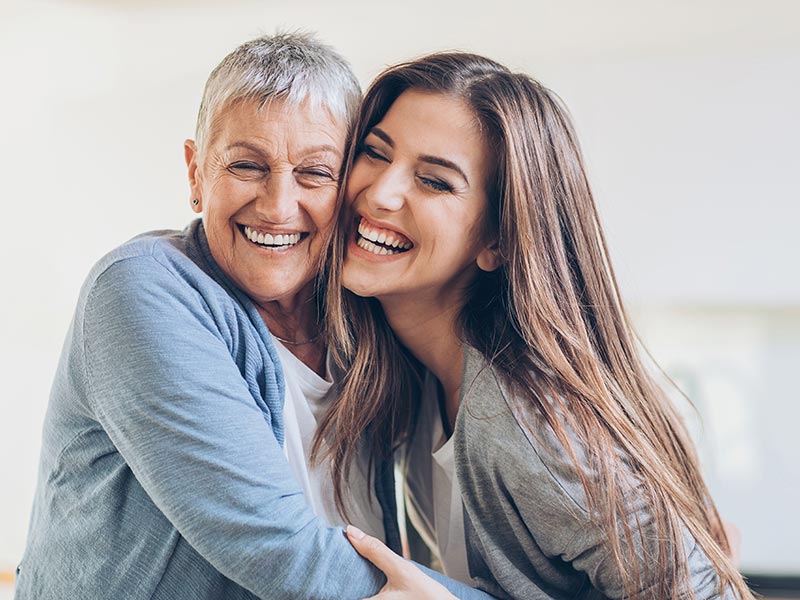 Mother and daughter hugging and laughing