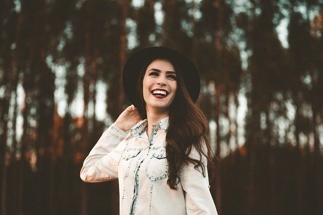 A women smiling in front of trees