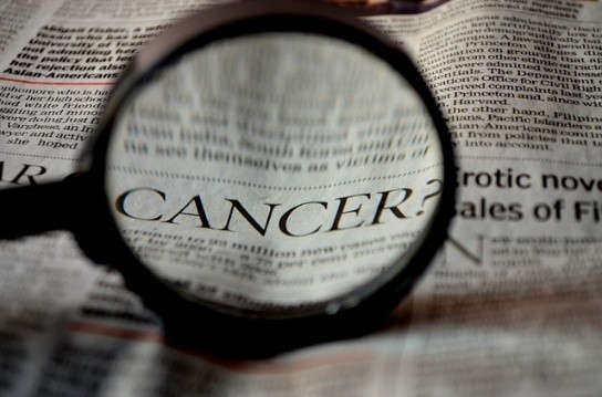 A close-up of a newspaper displaying significant cancer news