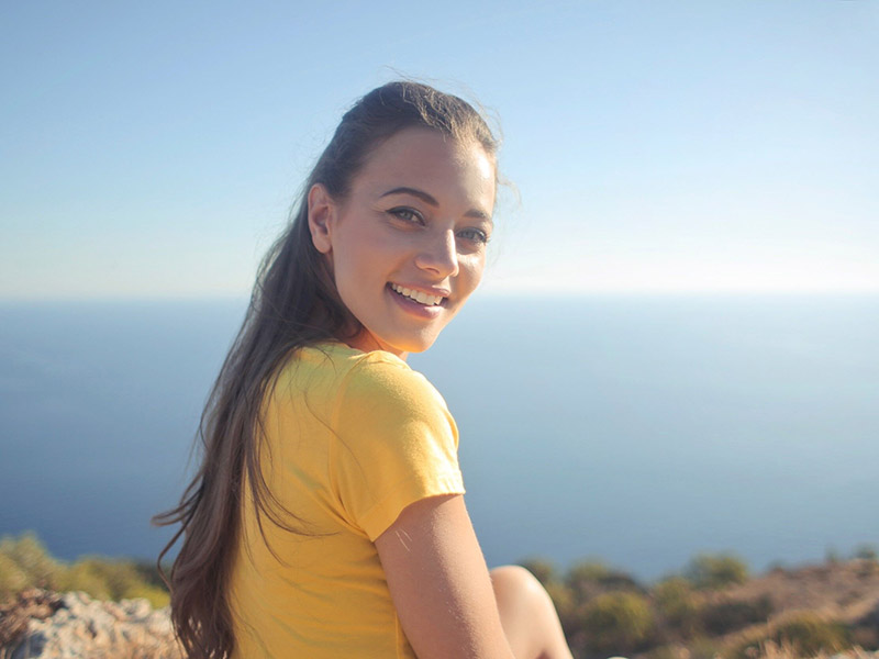 A girl smiling on a trek to the top of the mountain